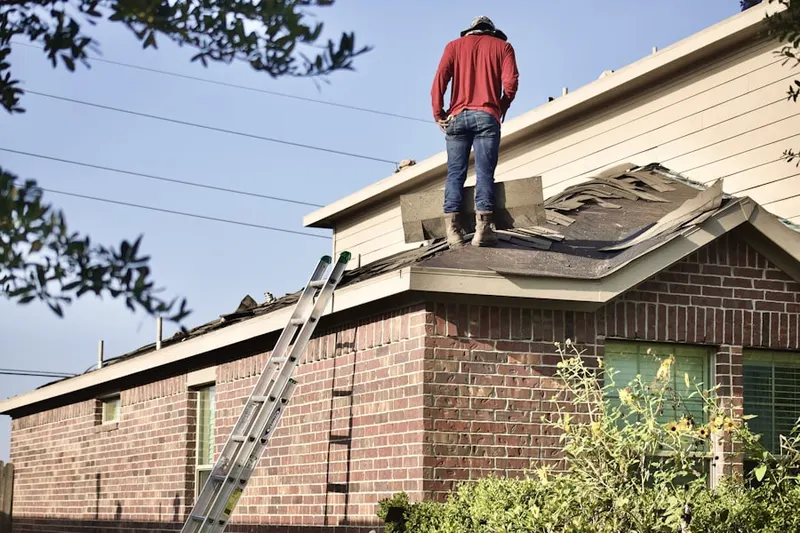 Professional roofer working on a residential roof in North Lynbrook